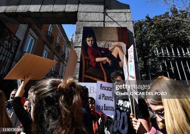 Students hold up placards and shout slogans as they march in front of the Thyssen-Bornemisza Museum during the "Fridays For Future" movement on a...