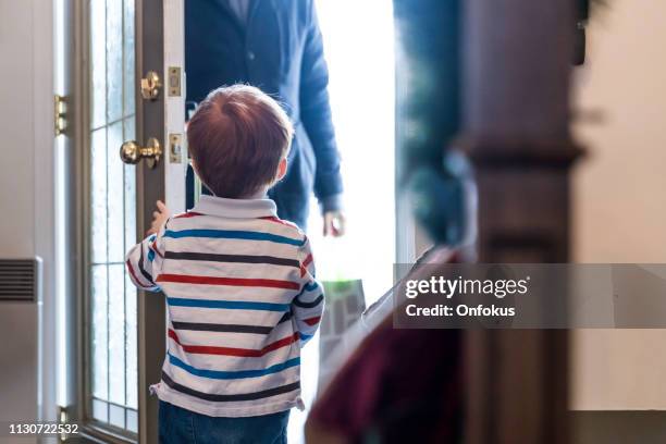 child opening door to father after day of work or delivery person - safe kids day arrivals stock pictures, royalty-free photos & images