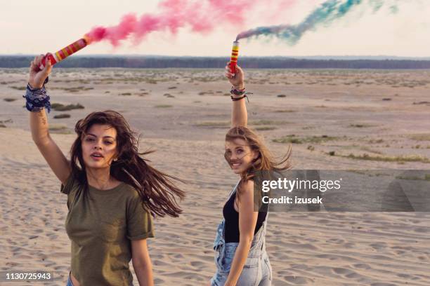 women holding distress flares at desert - distress flare stock pictures, royalty-free photos & images