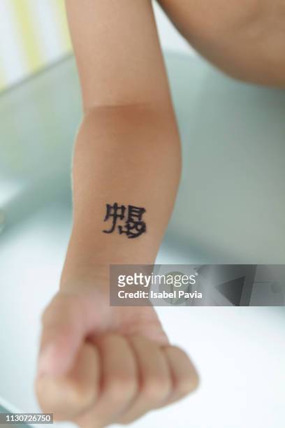 boy with tattoo on arm - heavy metal horns stock pictures, royalty-free photos & images