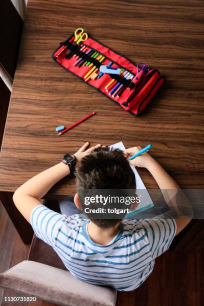 student boy schrijven naar notebook thuis - etui stockfoto's en -beelden