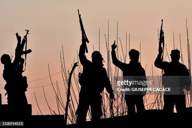 Backed Syrian Democratic Forces fighters celebrate after fighting Islamic State group jihadists near the village of Baghouz in the eastern Syrian...