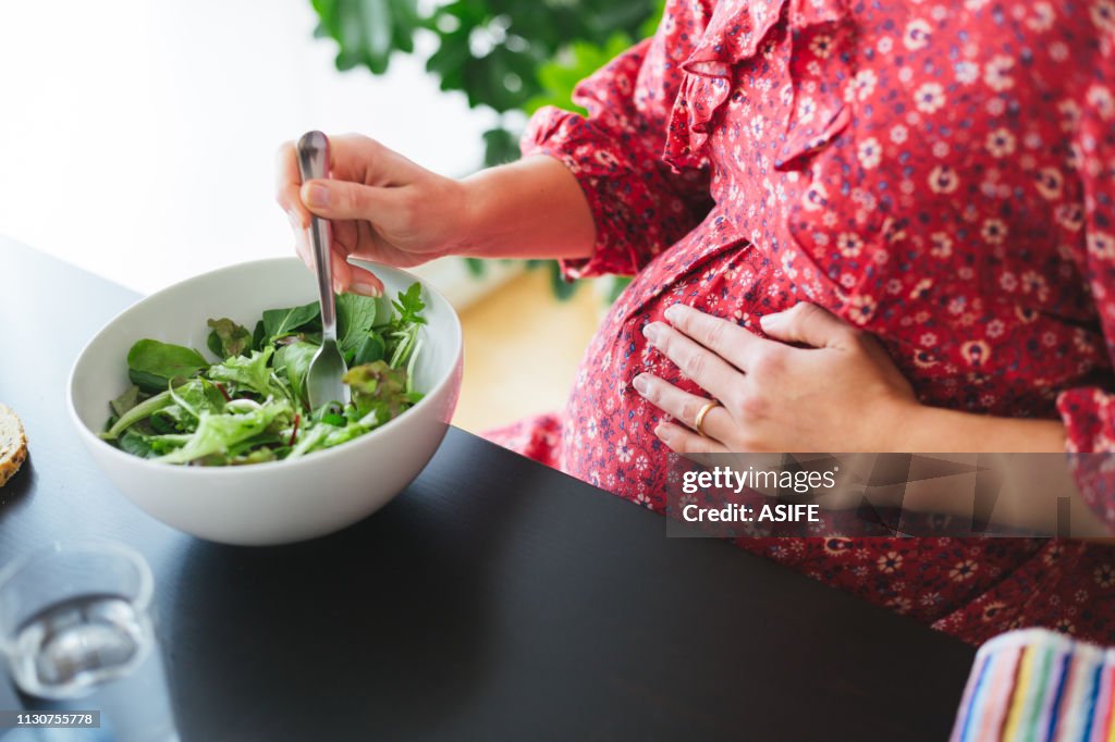Healthy pregnant woman eating a salad