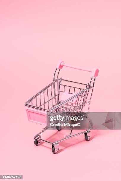 metallic small shopping cart on pink - store studios ストックフォトと画像