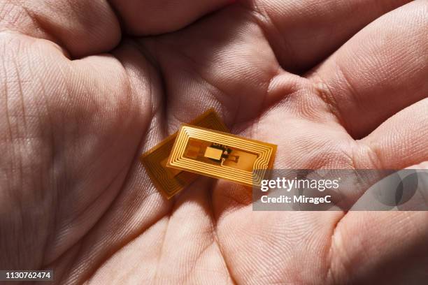 tiny rfid nfc labels in hand palm - nanotecnologia foto e immagini stock