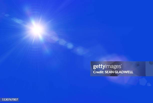 sun lens flare blue sky - blendenfleck stock-fotos und bilder