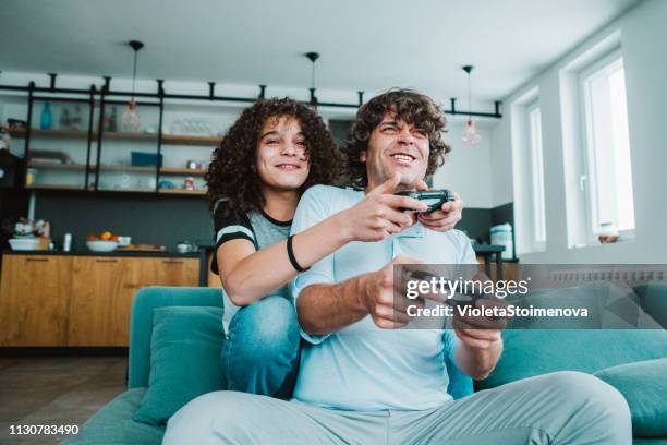 padre e hijo jugando juegos digitales en casa - parental control fotografías e imágenes de stock