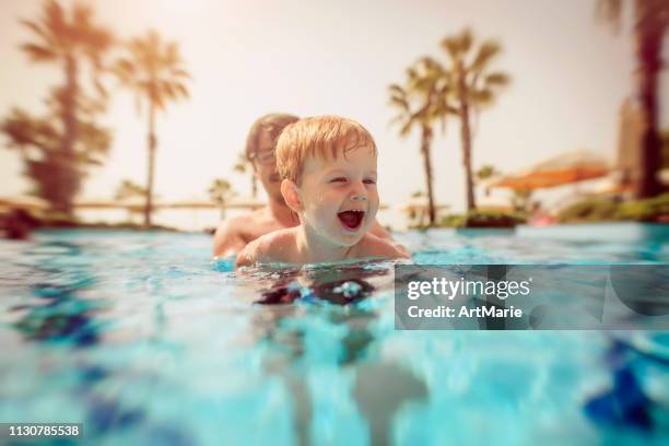 happy little boy with his father in swimming pool - lido stock pictures, royalty-free photos & images