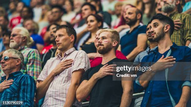 menschen auf einem stadion während einer nationalhymne bei einer sportveranstaltung - nationalhymne stock-fotos und bilder
