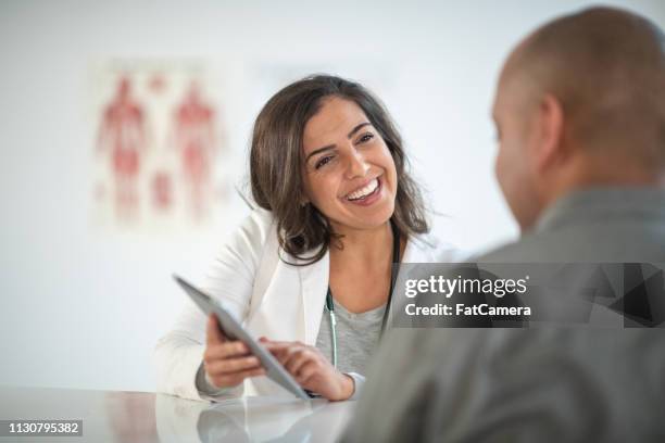 female doctor counseling patient in medical office - nutritionist stock pictures, royalty-free photos & images