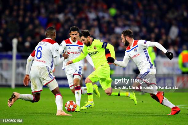 Lionel Messi of FC Barcelona is challenged by Marcelo, Lucas Tousart, and Houssem Aouar all of Olympique Lyonnais during the UEFA Champions League...