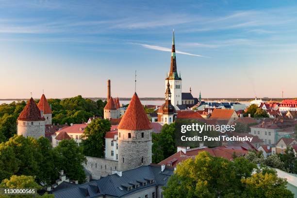 tallinn's old town with st olaf's church's spire towering above it, estonia - town wall tallinn stock pictures, royalty-free photos & images