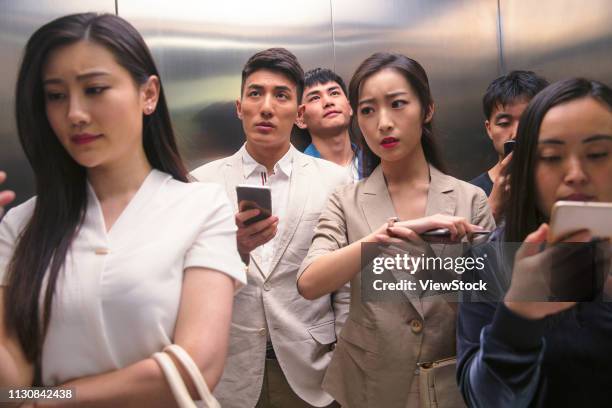 young men and women of the elevator - crowded elevator stockfoto's en -beelden