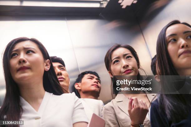 young men and women of the elevator - crowded elevator stockfoto's en -beelden