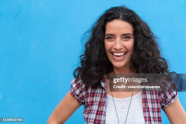 portrait of smiling mature women on blue background - 40 year old models stock pictures, royalty-free photos & images