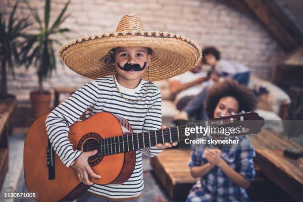 petit garçon mariachi jouant une guitare à la maison. - sombrero photos et images de collection