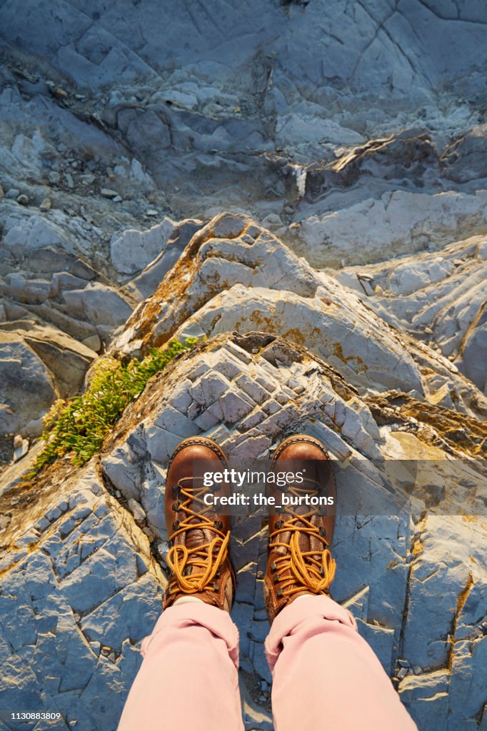 Woman in hiking boots standing on a rock