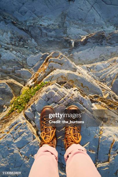 woman in hiking boots standing on a rock - hiking boot stock pictures, royalty-free photos & images