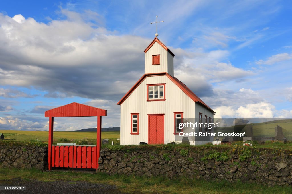 Little wooden church with red roof and red door