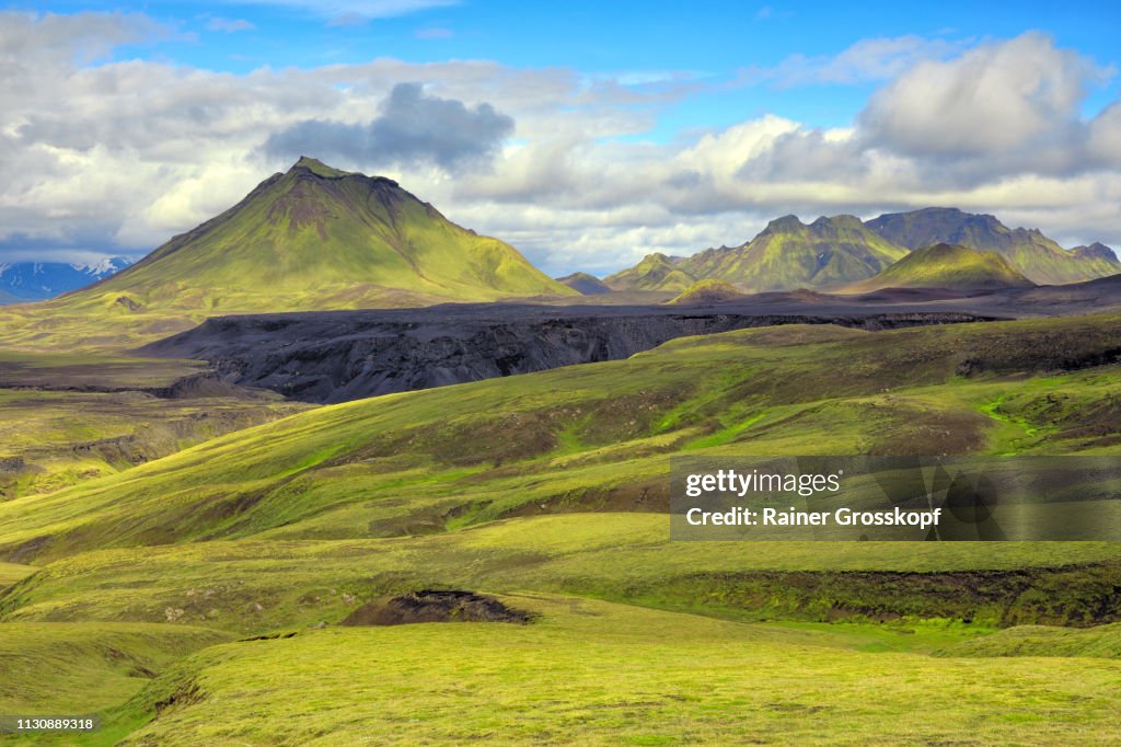 View across grassy and mossy green open land to mountain Hattafell