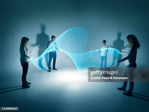 young people holding a lighttrace carpet - idea studio shot fotografías e imágenes de stock