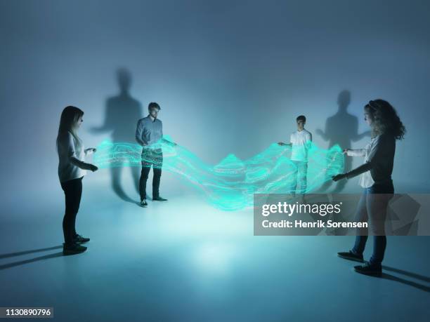 young people holding a lighttrace carpet - virtual networking stock pictures, royalty-free photos & images