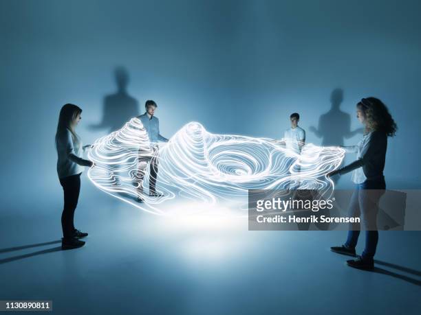 young people holding a lighttrace carpet - forecasting foto e immagini stock