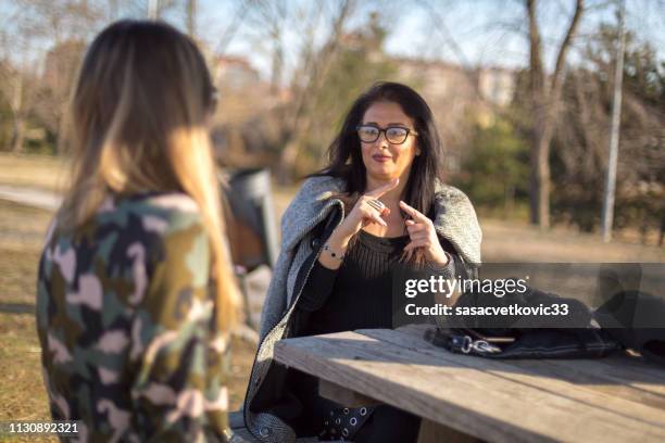 zwei frauen sprechen in gebärdensprache - american sign language stock-fotos und bilder