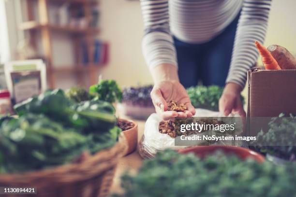 junge schwangere frau kauft gesundes essen im health food shop - bioladen stock-fotos und bilder