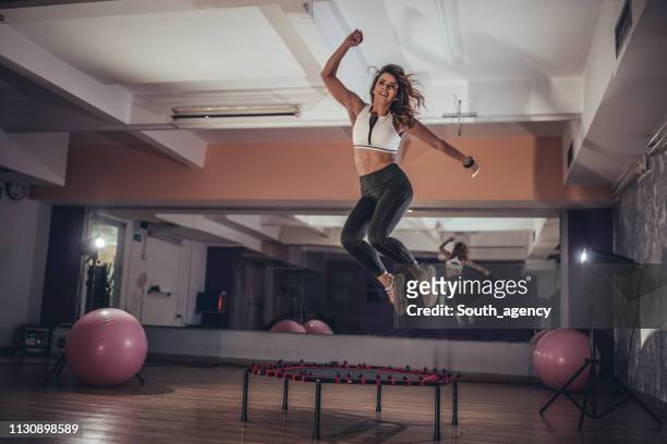 woman jumping on mini trampoline - trampoline stock pictures, royalty-free photos & images