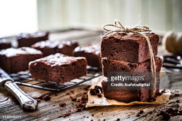 brownies al cioccolato fatti in casa girati su un tavolo rustico in legno - brownie foto e immagini stock