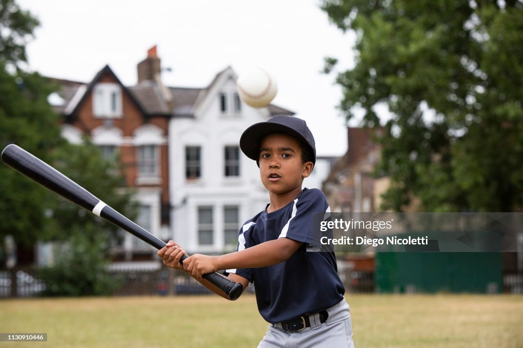 Young boy plays baseball, ready to hit the ball