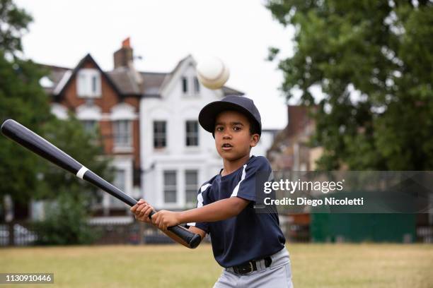 young boy plays baseball, ready to hit the ball - baseball hit stock pictures, royalty-free photos & images