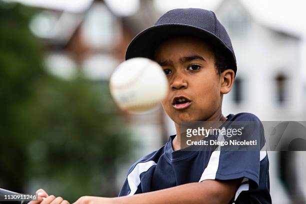 young boy plays baseball, ready to hit the ball - batting sports activity - fotografias e filmes do acervo