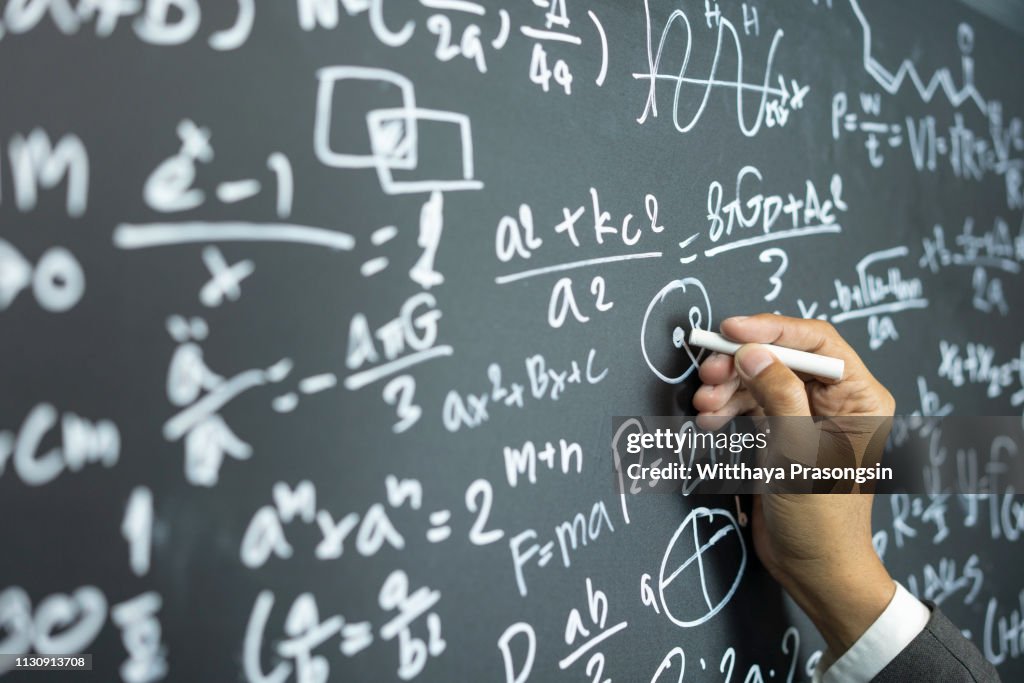 Professor writing on the board while having a chalk and blackboard lecture (shallow DOF; color toned image)