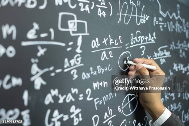 professor writing on the board while having a chalk and blackboard lecture (shallow dof; color toned image) - wiskunde stockfoto's en -beelden