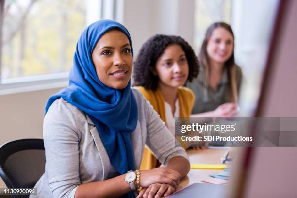 attentive businesswomen - muslim women in the workplace stock pictures, royalty-free photos & images