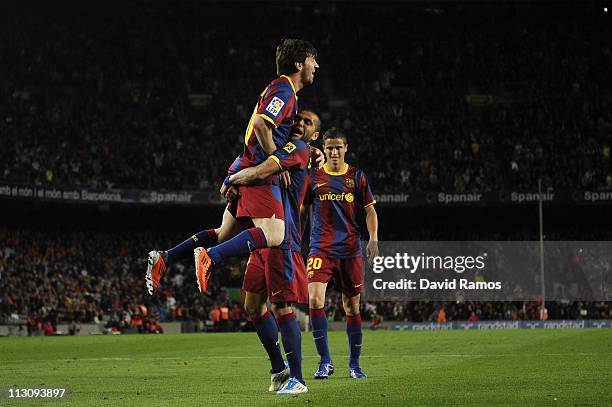 Lionel Messi of FC Barcelona celebrates with his teammates Dani Alves and Ibrahim Afellay after scoring his second team's goal during the La Liga...