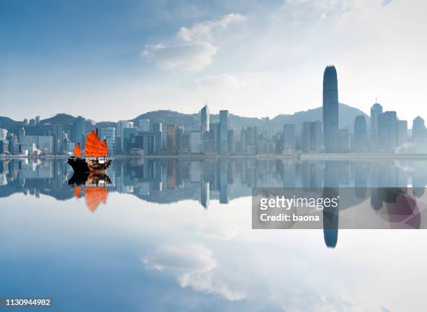 junk boat crossing hong kong harbor - china stock pictures, royalty-free photos & images