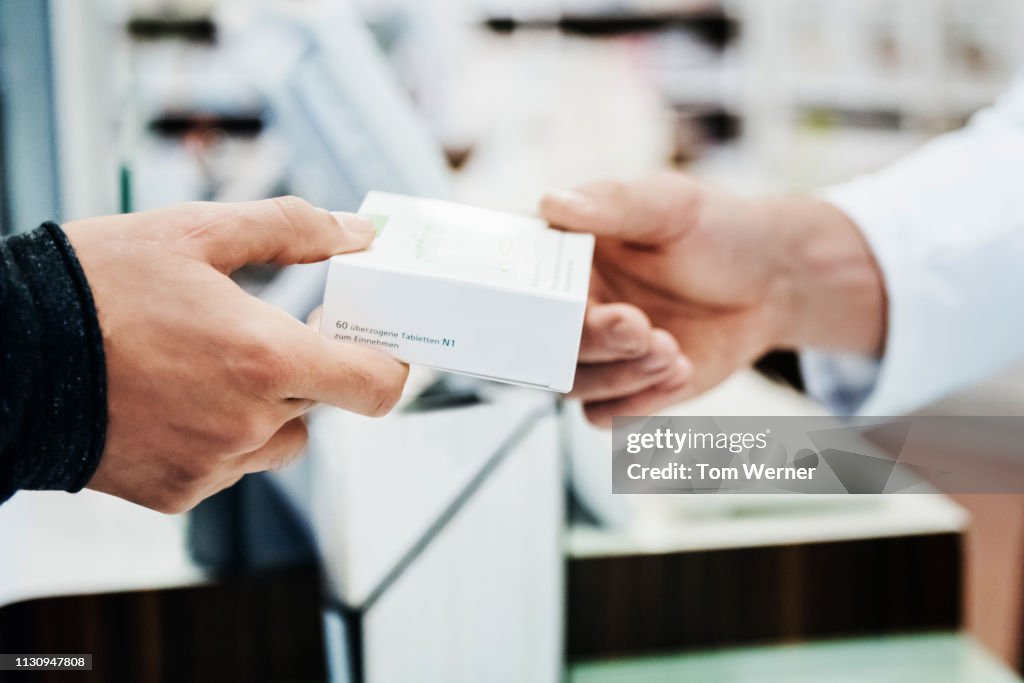 A Customer Receiving His Prescription From Pharmacy