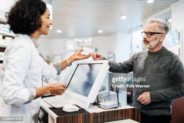 pharmacy giving customer his prescription - tom hale stock pictures, royalty-free photos & images