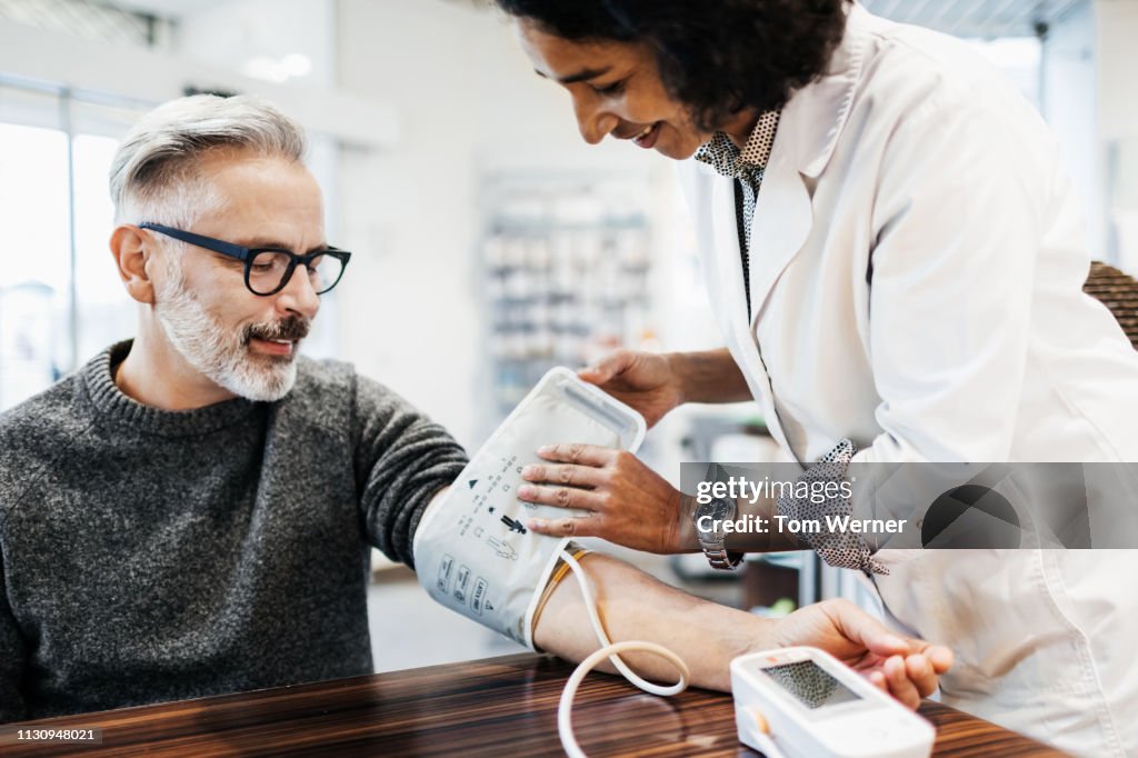 Pharmacist Measuring Mature Man's Blood Pressure