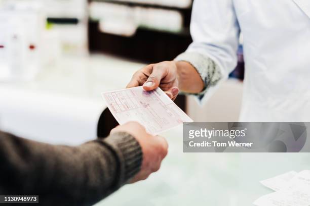 customer handing prescription to pharmacist - prescription medicine stock pictures, royalty-free photos & images