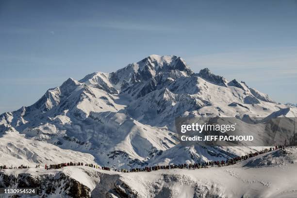 Spectators wait skiers in front of the Mont Blanc during the fourth and last stage of the 34th edition of the ski-mountaineering race, the...