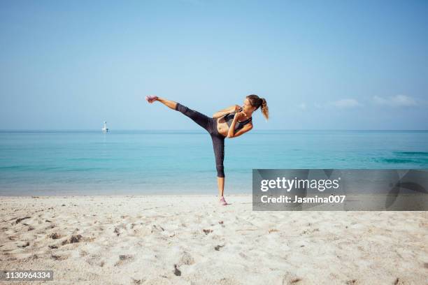 athlete doing exercises on the beach - karate woman stock pictures, royalty-free photos & images