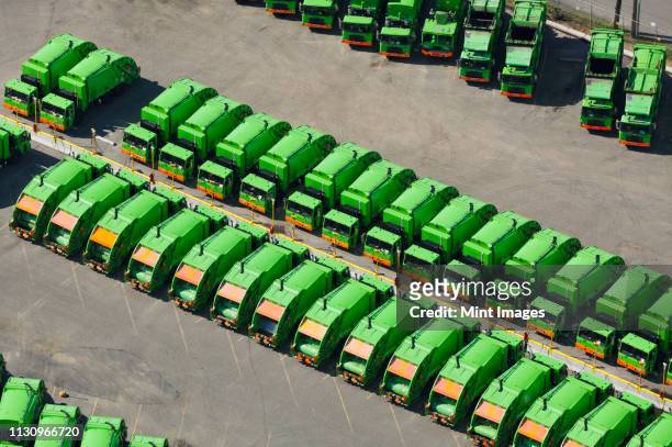 aerial view of green garbage trucks in a row in parking lot - garbage truck fotografías e imágenes de stock