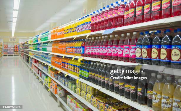 bottled juice on supermarket shelves - supermarket shelves stock-fotos und bilder