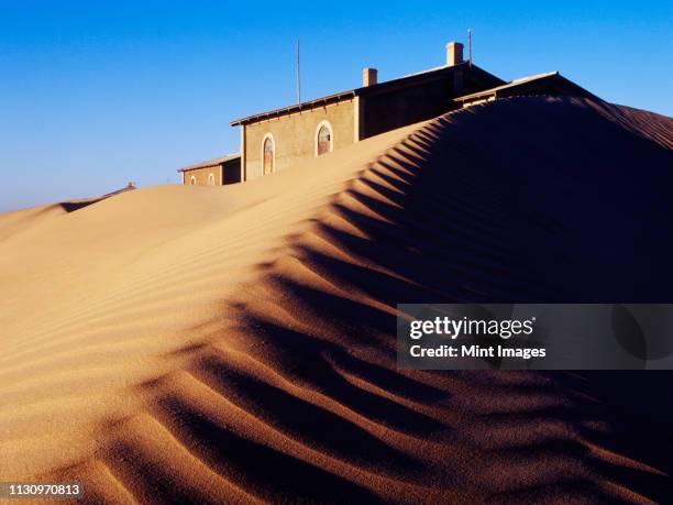 house buried in sand - kolmanskop stockfoto's en -beelden