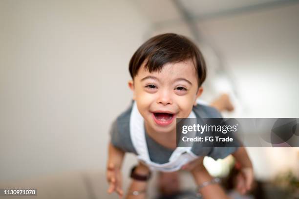 moeder gooien haar zoon met down syndroom thuis - down syndrome baby stockfoto's en -beelden