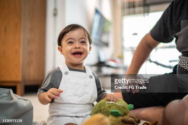 down syndrome son playing at home - down syndrome baby stock pictures, royalty-free photos & images